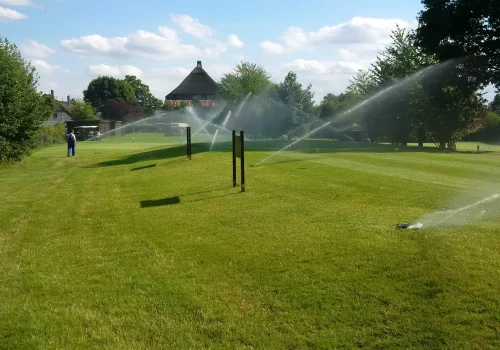 Mehrere Versenkregner bewässern die Rasenfläche eines Golfclubs am Timmendorfer Strand.